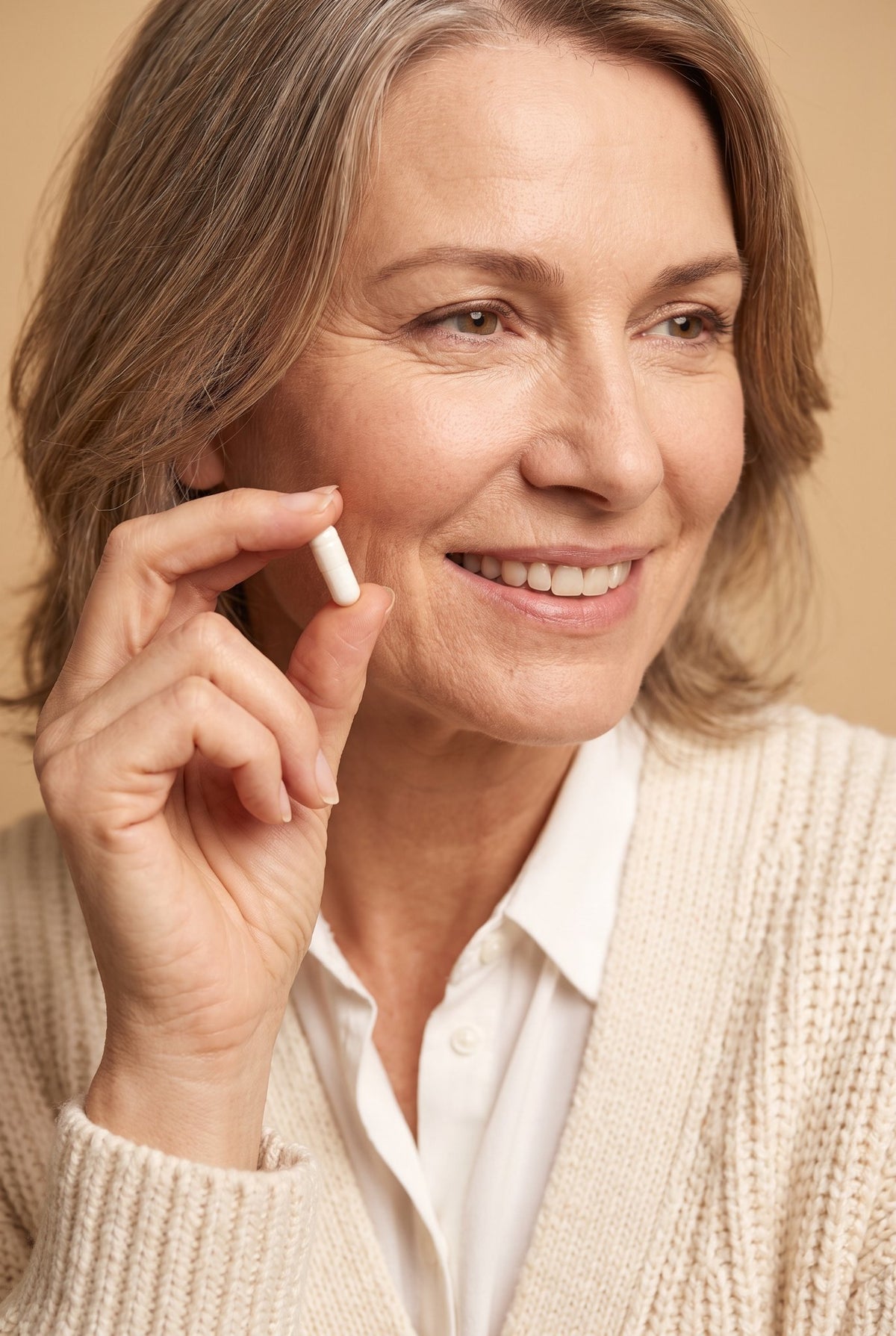 Woman in her 50s smiling and holding a Relvaya capsule